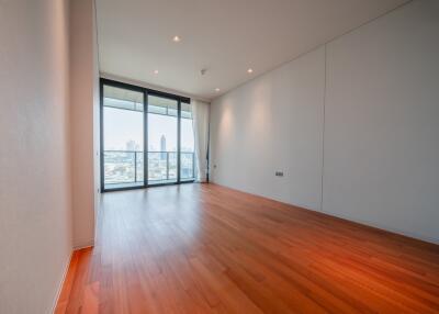 Spacious living room with wooden flooring and large floor-to-ceiling windows.