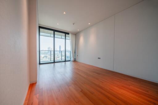 Spacious living room with wooden flooring and large floor-to-ceiling windows.