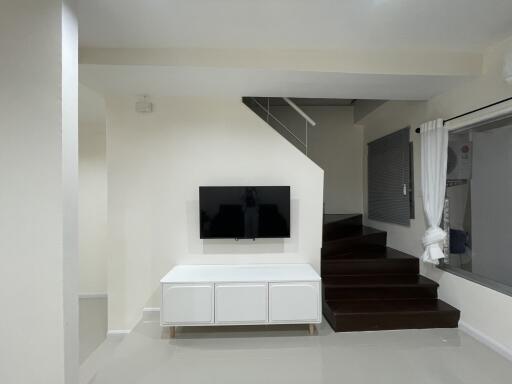 Modern living room with TV and staircase