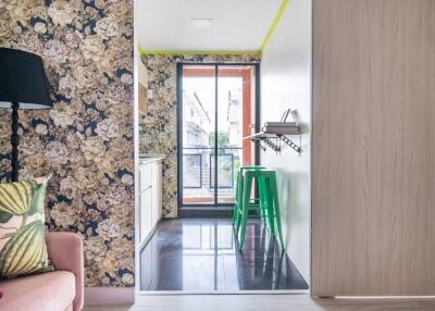 Modern kitchen with floral wallpaper and green stools