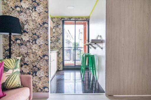 Modern kitchen with floral wallpaper and green stools