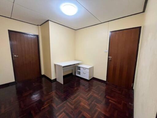 Empty bedroom with wooden floors and two doors