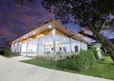 Modern house with large glass windows and surrounding greenery