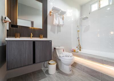 Modern bathroom with vanity, mirror, toilet, and a bathtub