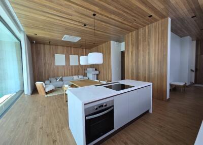 Modern living room with wooden accents and kitchen area