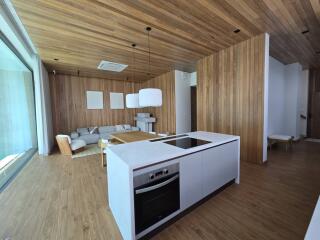 Modern living room with wooden accents and kitchen area