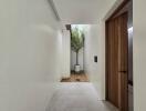 Modern hallway with a small indoor courtyard and a wooden door