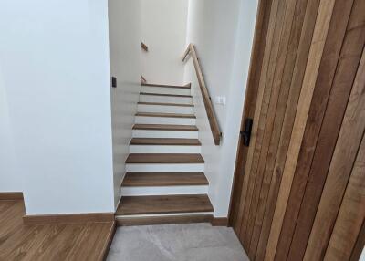 Wooden staircase with railing and adjacent wooden door