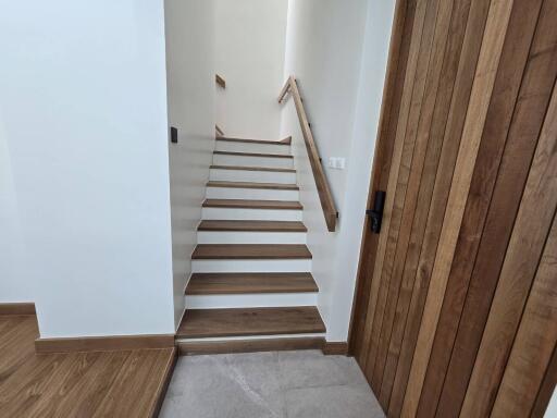 Wooden staircase with railing and adjacent wooden door