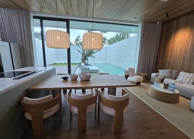 Modern living room with wooden ceiling, dining area, and view of outdoor pool