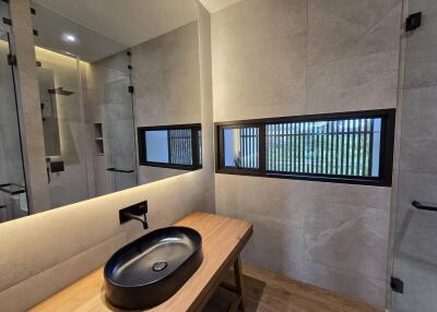 Modern bathroom with black fixtures and wooden countertop