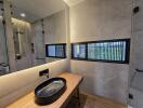 Modern bathroom with black fixtures and wooden countertop