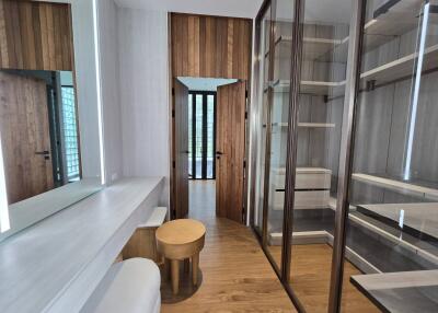 Modern dressing room with vanity area and ample shelving