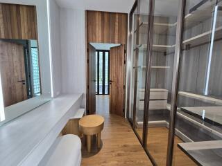 Modern dressing room with vanity area and ample shelving