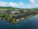 Aerial view of a waterfront residential complex with greenery and mountains in the background