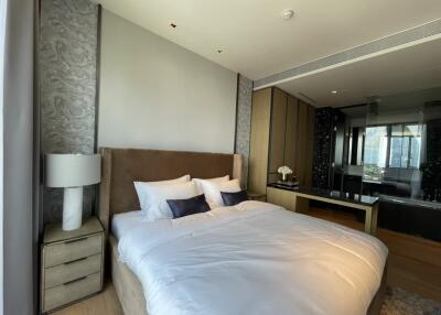 Modern bedroom with a large bed, side table, and a large window with a view.