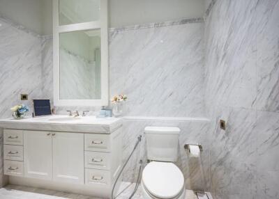 Well-lit bathroom with white marble walls and modern fixtures