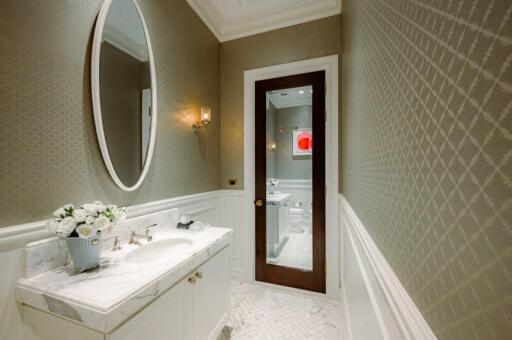 Elegant bathroom with marble sink and oval mirror