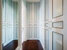 Spacious walk-in closet with ample storage space featuring white paneled doors and gold accents.