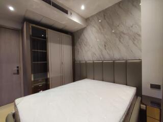 Modern bedroom with marble accent wall and built-in wardrobe