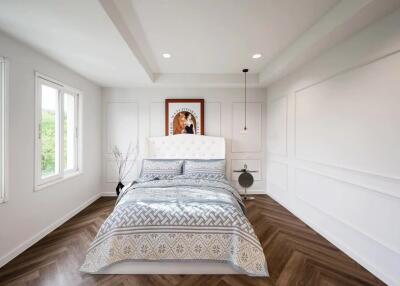 Modern bedroom with white walls, wooden floor, and a large bed