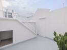 Outdoor balcony with staircase and white walls