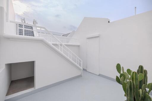 Outdoor balcony with staircase and white walls