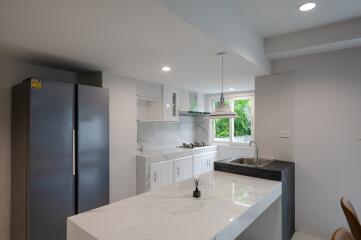 Modern kitchen with island and stainless steel refrigerator