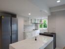 Modern kitchen with island and stainless steel refrigerator