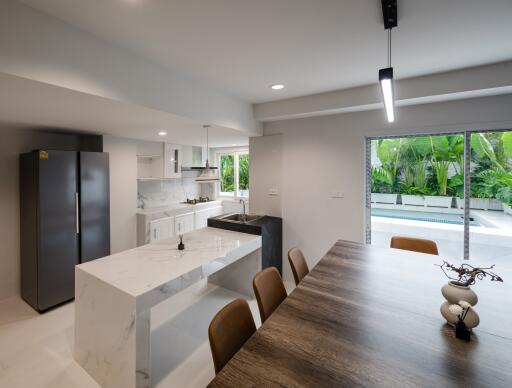 Modern kitchen with an adjoining dining area and view of the backyard pool