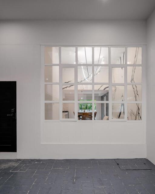 View of interior space through window with decorative lamp and seating area