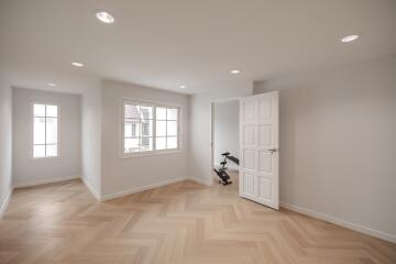 Bright room with wooden herringbone floor and exercise bike