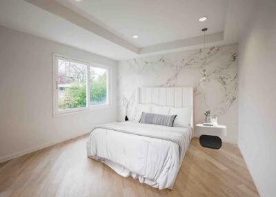 Modern bedroom with large window and marble accent wall