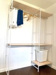 Bedroom closet with hanging rod and storage shelves