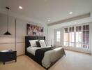 Modern bedroom with large windows and wall-mounted painting