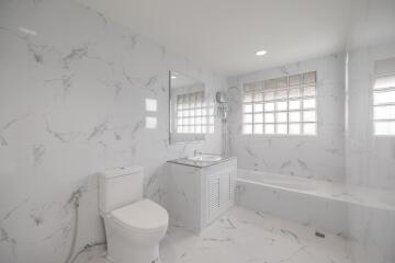 Spacious bathroom with marble walls and floor