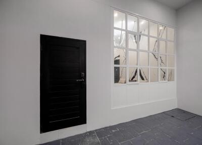 Entryway with black door and large interior window