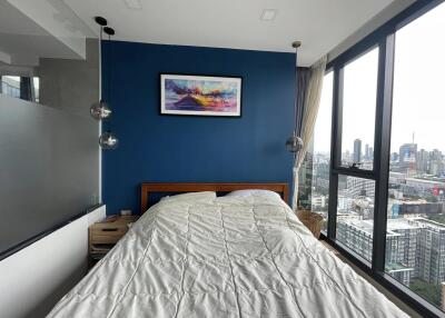 Modern bedroom with large windows and a city view