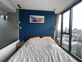 Modern bedroom with large windows and a city view