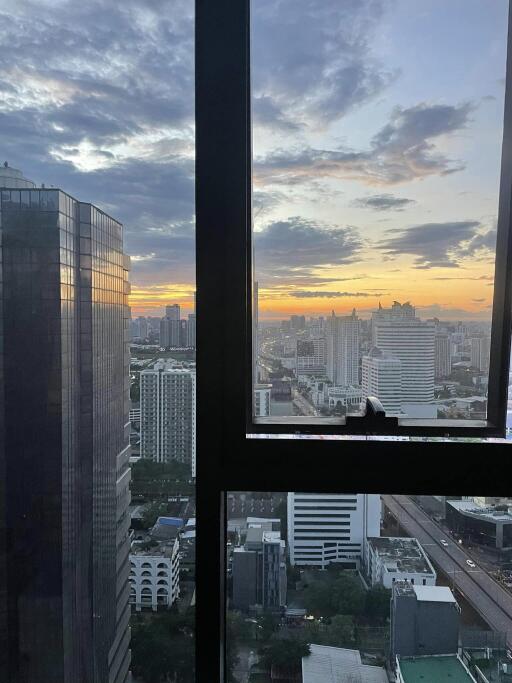 City view from high-rise building window during sunset