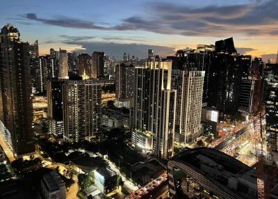 City skyline view at dusk with lit buildings and traffic