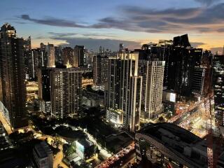 City skyline view at dusk with lit buildings and traffic