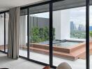 Modern living room with large glass doors leading to a balcony with city view