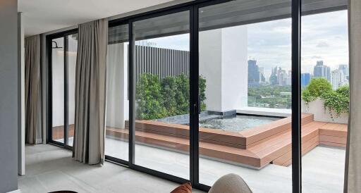 Modern living room with large glass doors leading to a balcony with city view