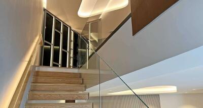 Modern staircase with glass railing and ambient lighting