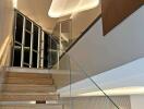 Modern staircase with glass railing and ambient lighting