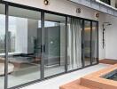 Modern living space with glass doors leading to a terrace featuring greenery and a small pool