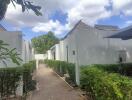 Outdoor view of the property with white buildings and green shrubs