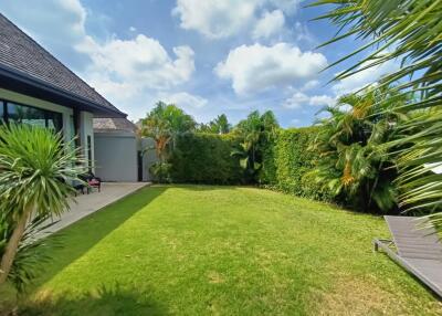 Spacious backyard with lush greenery and well-maintained lawn