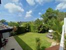 Spacious outdoor backyard with well-maintained lawn and various plants